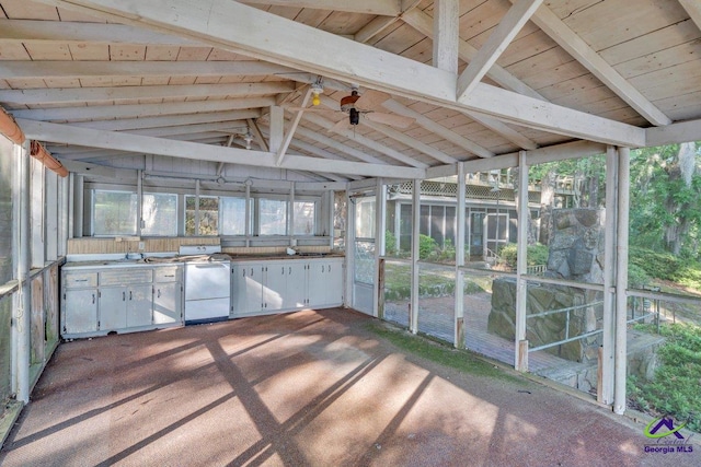 unfurnished sunroom featuring beamed ceiling, exterior kitchen, and a wealth of natural light