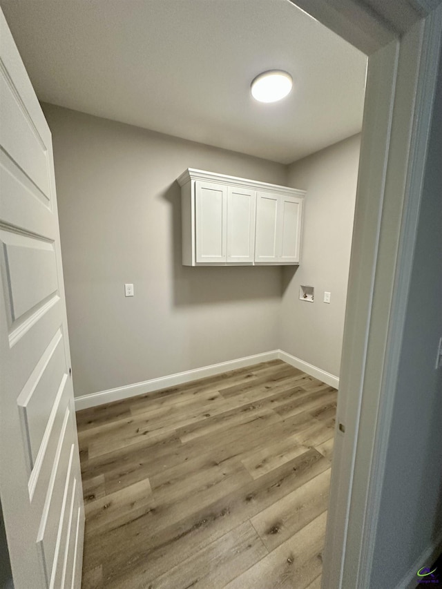 laundry area featuring washer hookup, baseboards, laundry area, and light wood finished floors