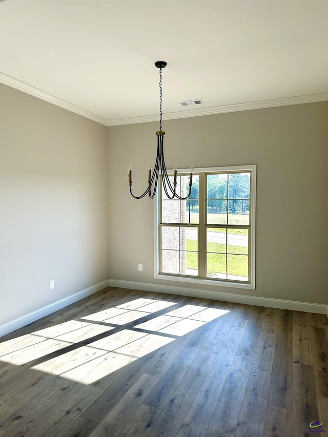 unfurnished dining area featuring wood-type flooring, baseboards, a notable chandelier, and crown molding