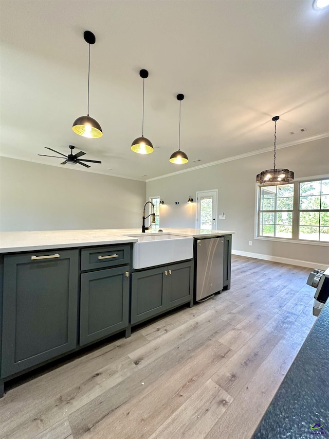 kitchen with crown molding, pendant lighting, a sink, light wood-style flooring, and dishwasher