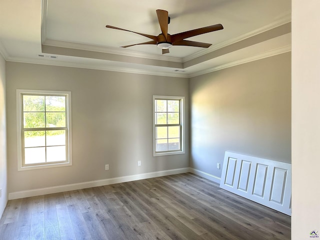 spare room featuring crown molding, a ceiling fan, a tray ceiling, and wood finished floors