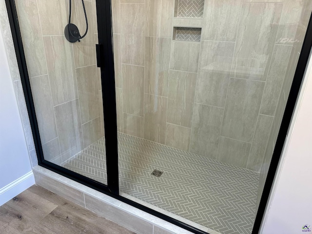 bathroom featuring a shower stall and wood finished floors