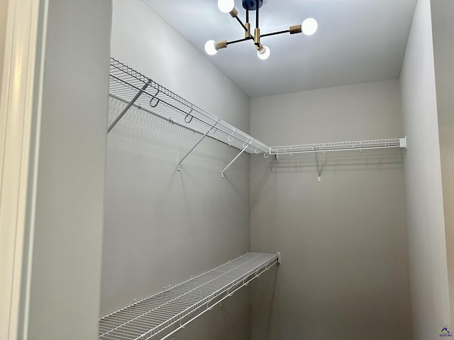 walk in closet with a chandelier
