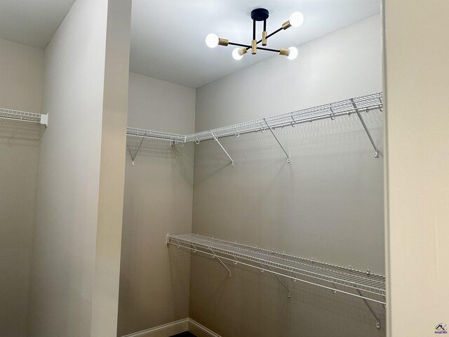 spacious closet with an inviting chandelier