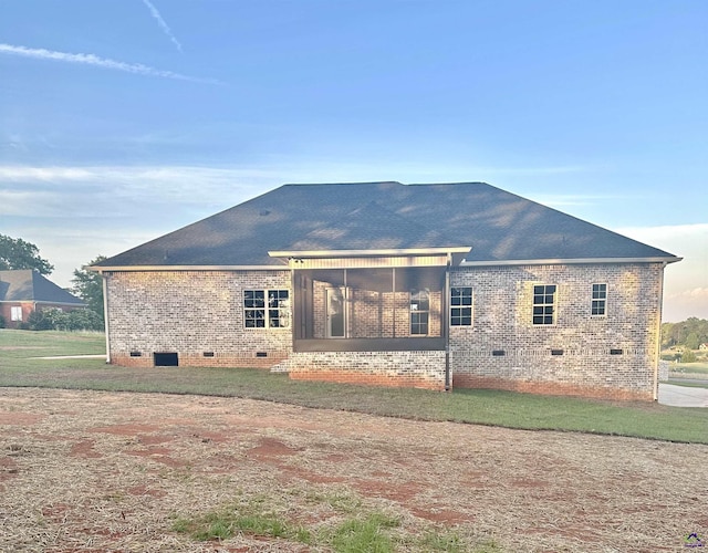 back of property featuring brick siding, a shingled roof, a sunroom, and crawl space