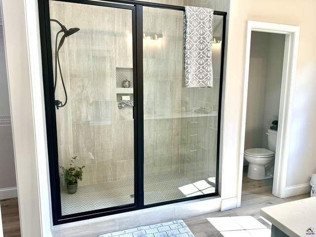 84 Camden Way, Hawkinsville, GA 31036 - full bathroom with a stall shower, wood finished floors, toilet, vanity, and baseboards