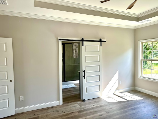 84 Camden Way, Hawkinsville, GA 31036 - empty room featuring a barn door, ceiling fan, ornamental molding, wood finished floors, and baseboards