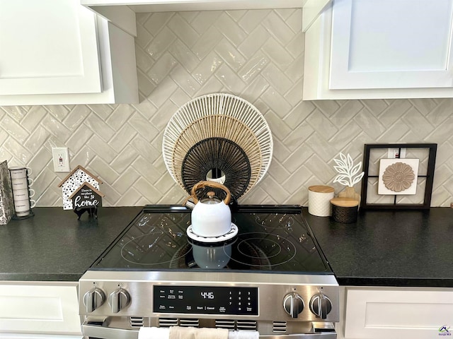 84 Camden Way, Hawkinsville, GA 31036 - kitchen view of tasteful backsplash, stainless steel electric range oven, white cabinets, and dark countertops