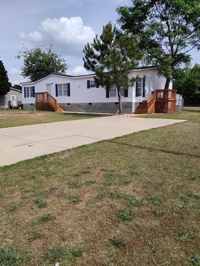 manufactured / mobile home with crawl space, a wooden deck, and a front lawn