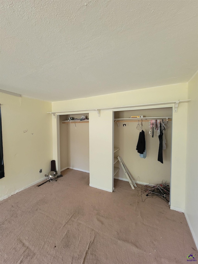 unfurnished bedroom with a closet, carpet flooring, and a textured ceiling