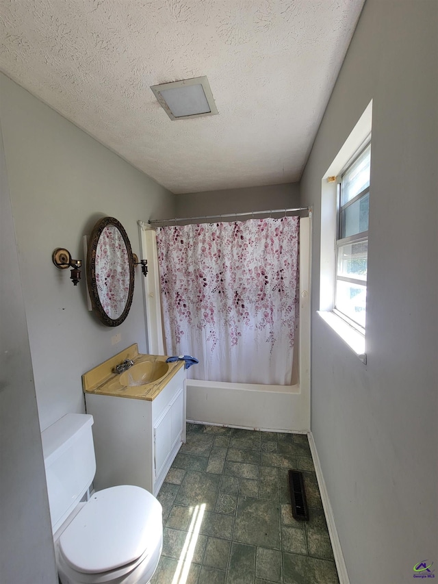 full bath featuring vanity, shower / tub combo with curtain, visible vents, toilet, and a textured ceiling
