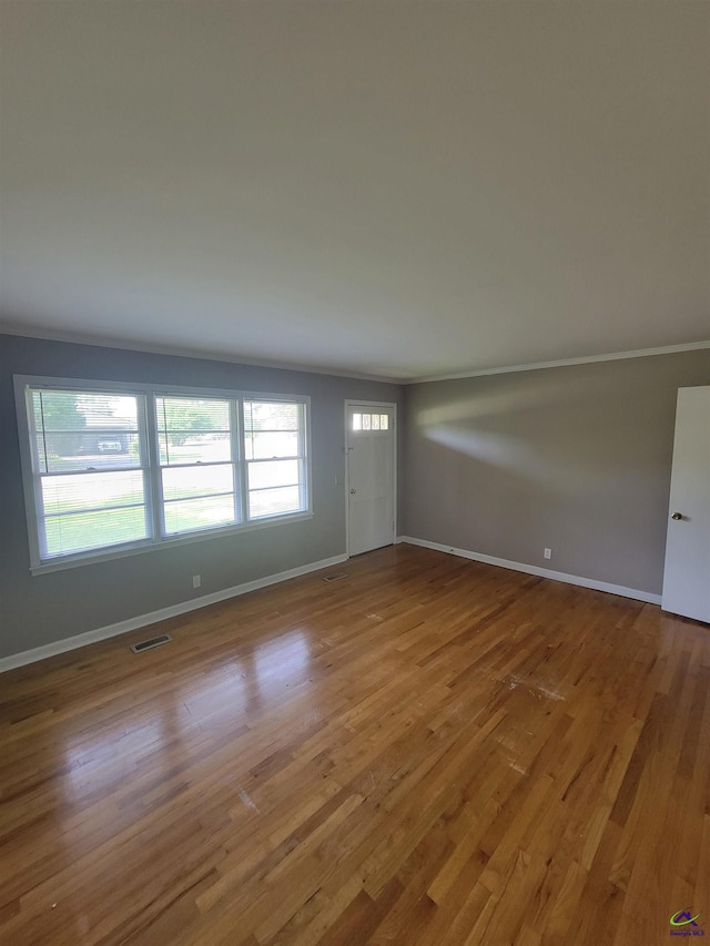 unfurnished living room with baseboards, wood finished floors, and visible vents