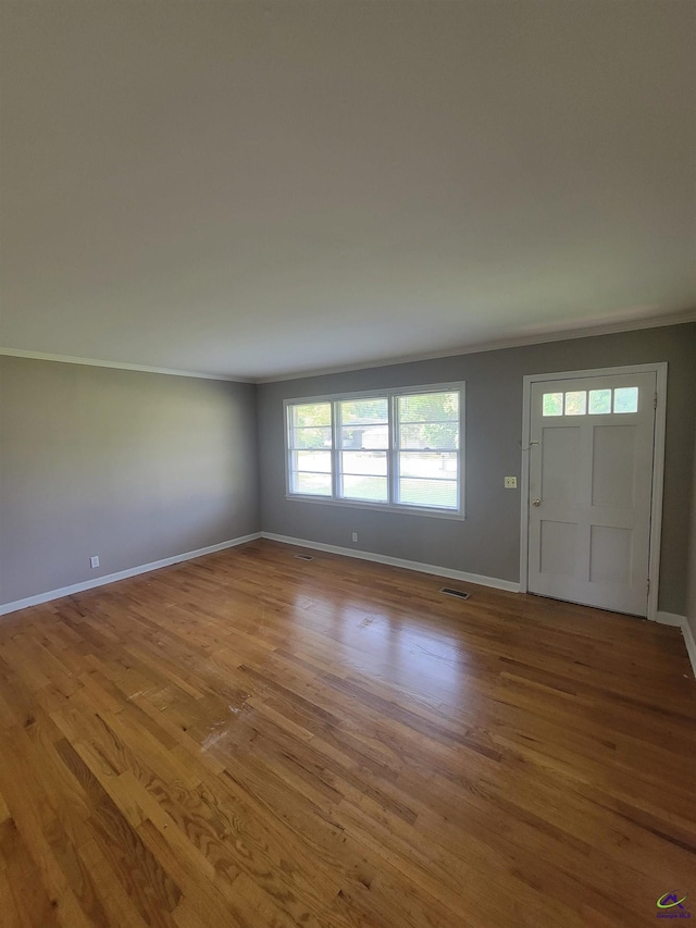 interior space featuring baseboards, visible vents, and wood finished floors