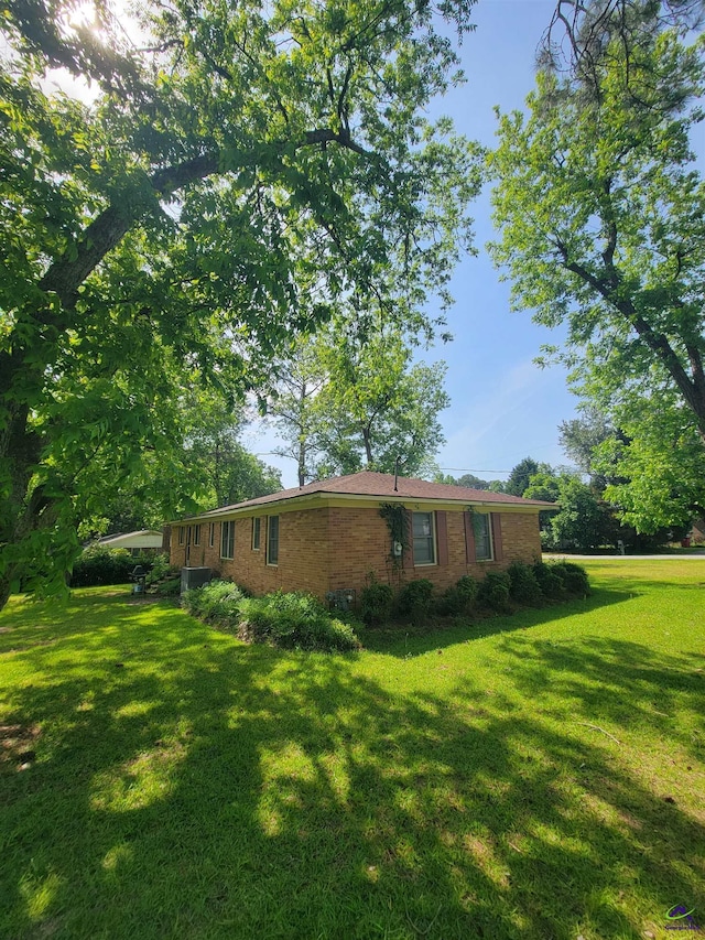 exterior space featuring a lawn and brick siding