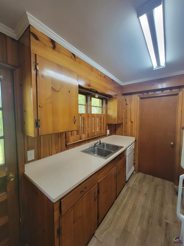 kitchen featuring white dishwasher, a sink, light countertops, light wood-style flooring, and ornamental molding