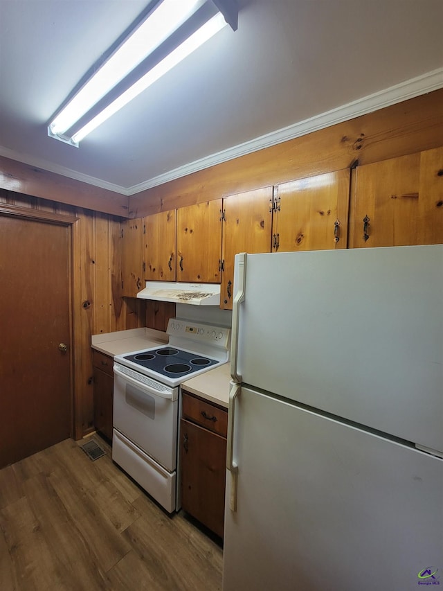 kitchen with wood finished floors, white appliances, light countertops, under cabinet range hood, and brown cabinets