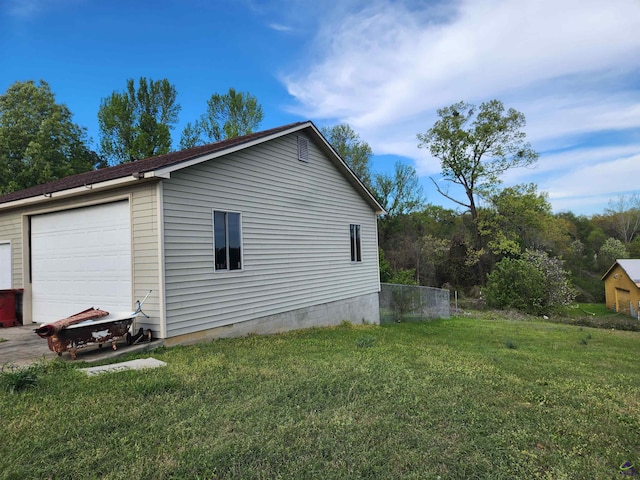 view of side of property with a garage, an outdoor structure, and a yard