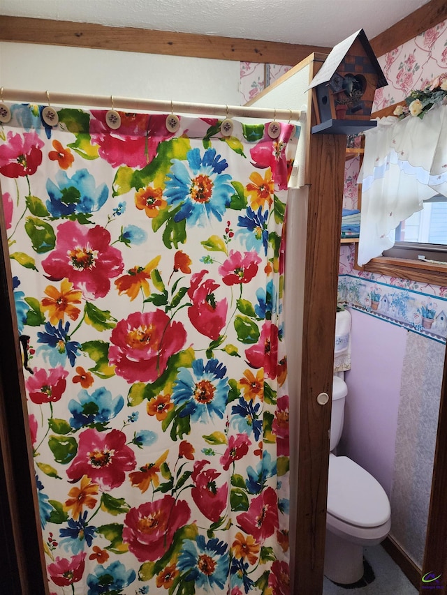 full bathroom featuring toilet, wallpapered walls, and a shower with shower curtain