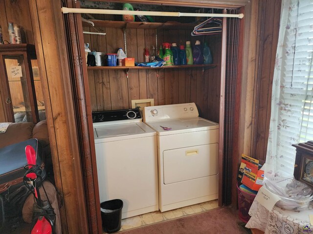washroom with laundry area, wooden walls, and washing machine and clothes dryer