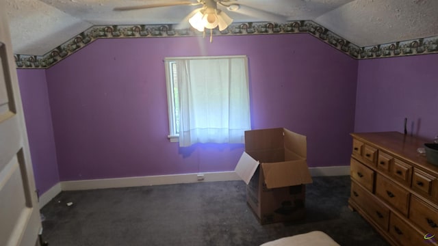 bedroom with baseboards, vaulted ceiling, dark colored carpet, and a textured ceiling