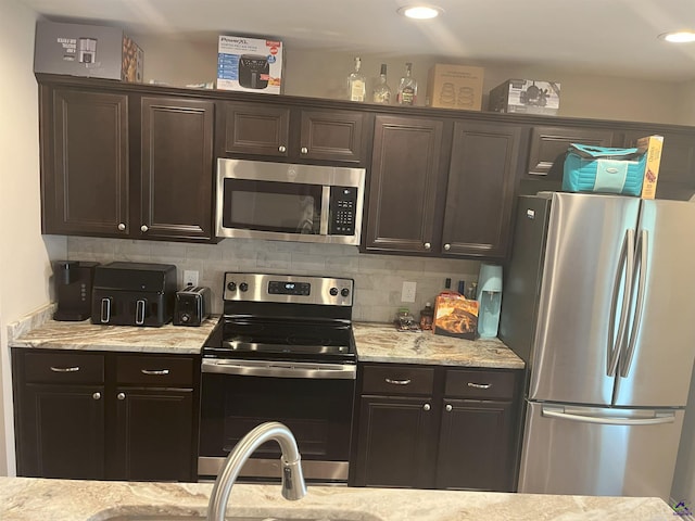 107 Red Tail Cir, Byron, GA 31008 - kitchen with appliances with stainless steel finishes, dark brown cabinetry, and tasteful backsplash