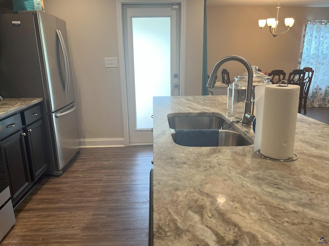 107 Red Tail Cir, Byron, GA 31008 - kitchen with dark wood-style flooring, a sink, baseboards, freestanding refrigerator, and an inviting chandelier