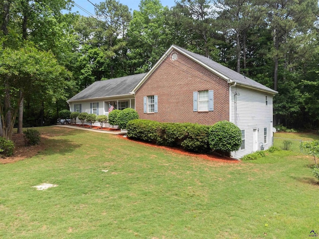 view of front of house featuring brick siding and a front yard