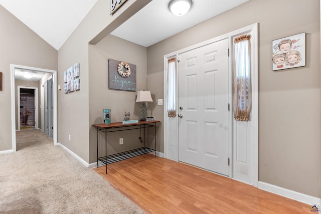 foyer entrance featuring baseboards and wood finished floors