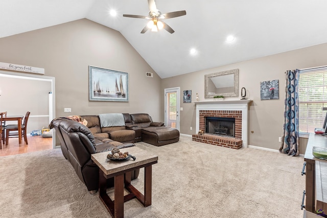 carpeted living room with a brick fireplace, high vaulted ceiling, a ceiling fan, baseboards, and visible vents