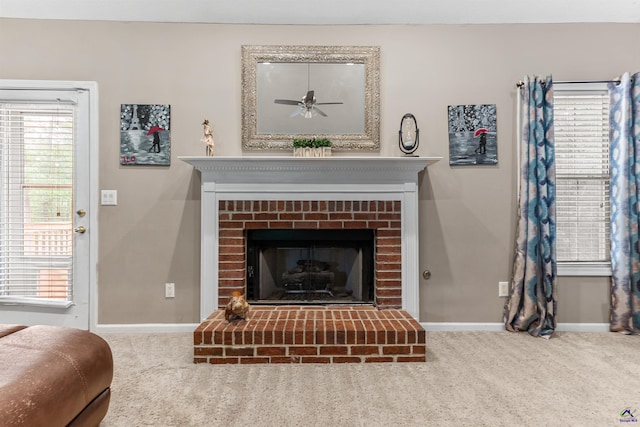 living area featuring baseboards, ceiling fan, a fireplace, and carpet flooring