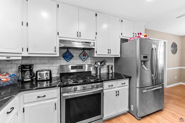 kitchen featuring dark countertops, appliances with stainless steel finishes, light wood finished floors, under cabinet range hood, and white cabinetry