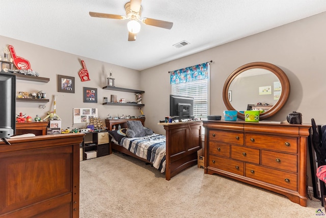 bedroom with a textured ceiling, ceiling fan, light colored carpet, and visible vents