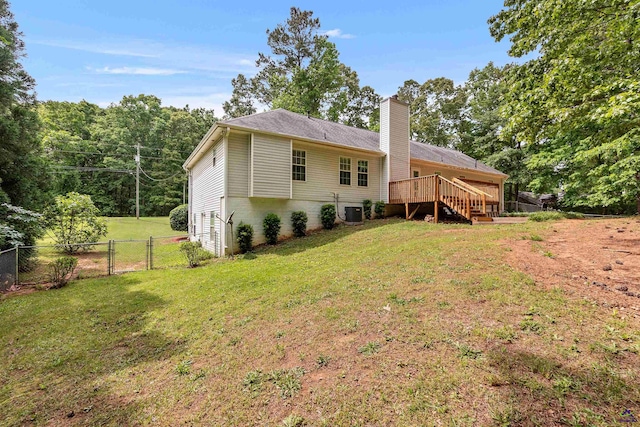rear view of property with fence, a chimney, stairs, a gate, and a lawn