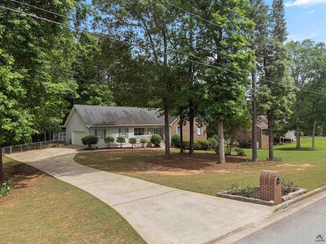 view of front of home with concrete driveway, an attached garage, fence, and a front yard