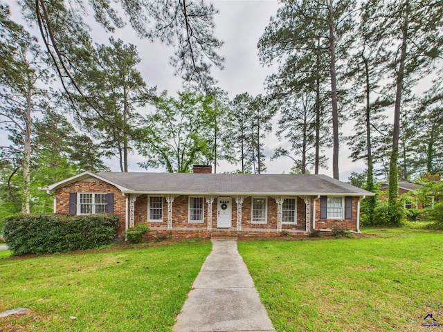 single story home with brick siding, a front lawn, and a chimney