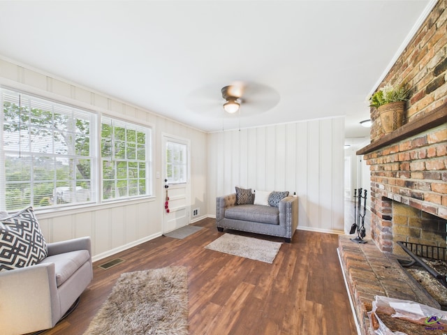 living room featuring visible vents, ornamental molding, wood finished floors, baseboards, and a ceiling fan