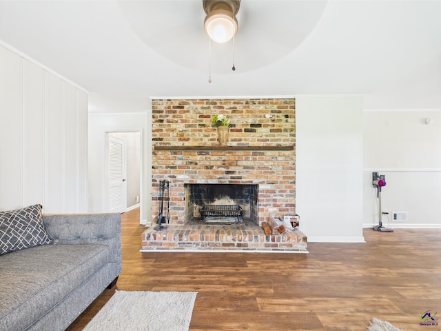 living room featuring crown molding, a ceiling fan, wood finished floors, and visible vents