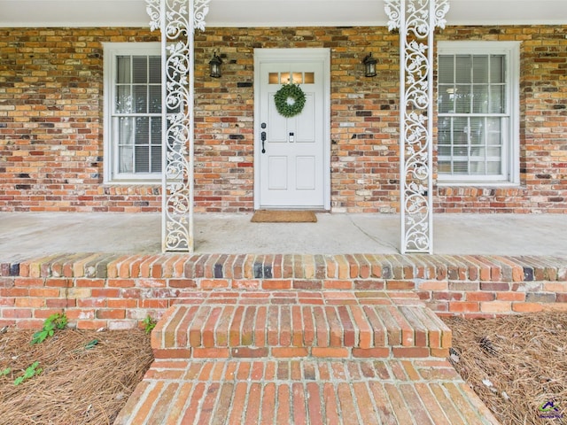 entrance to property with brick siding and covered porch