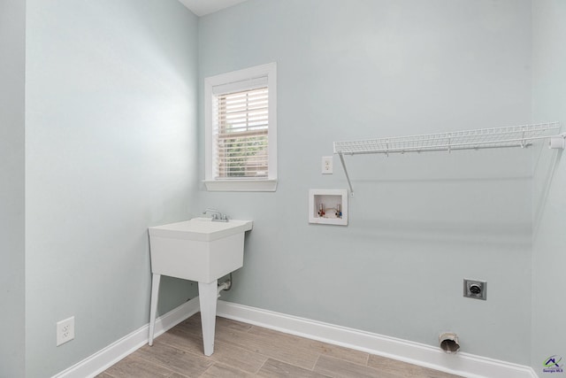 laundry room with laundry area, baseboards, hookup for an electric dryer, light wood-style flooring, and washer hookup