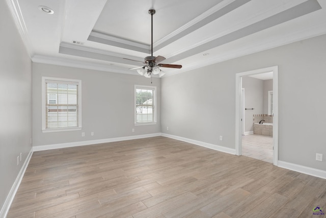 interior space with a ceiling fan, visible vents, crown molding, light wood-style floors, and a tray ceiling