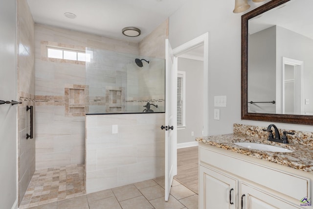 bathroom featuring a walk in shower and vanity