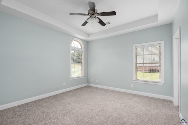 unfurnished room featuring carpet flooring, baseboards, and a raised ceiling