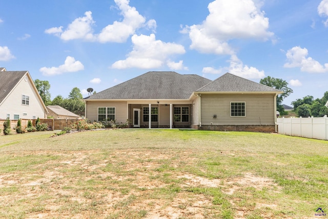 back of property featuring fence and a yard