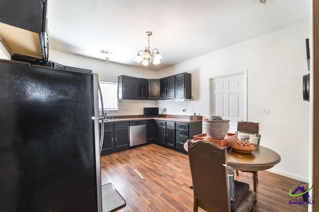 kitchen featuring dark wood-style flooring, a notable chandelier, appliances with stainless steel finishes, a sink, and visible vents
