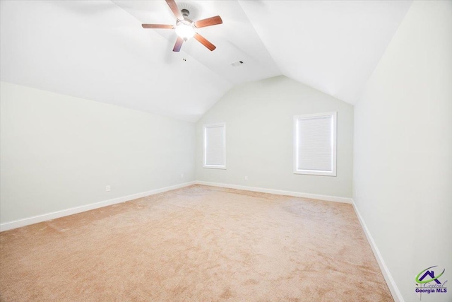 additional living space featuring light colored carpet, vaulted ceiling, baseboards, and a ceiling fan