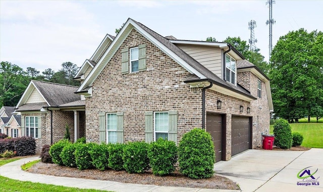 view of side of home featuring an attached garage, brick siding, driveway, and roof with shingles