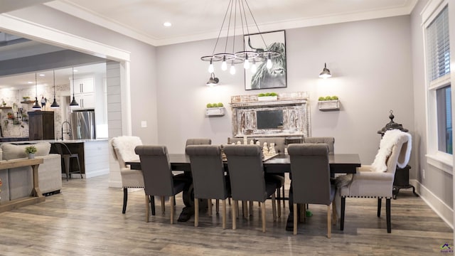 dining space featuring crown molding, recessed lighting, baseboards, and wood finished floors