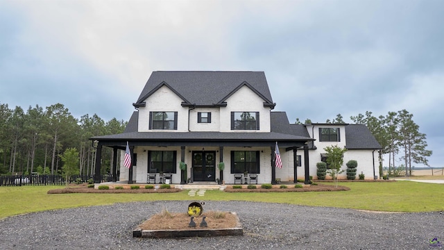 modern inspired farmhouse with covered porch, fence, and a front yard