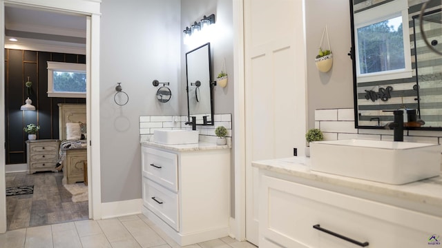 full bath featuring baseboards, tile patterned flooring, vanity, and tasteful backsplash
