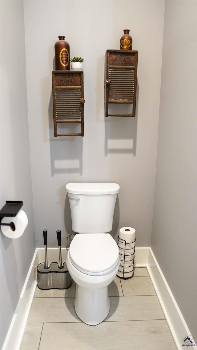 bathroom with toilet and baseboards